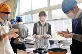 調理実習でハンバーグ作りに挑戦。楽しげな生徒たちの声は廊下まで届いていた＝山南中学校
