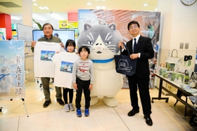藤田光人・丹波総局長（右）から記念品を受けとった宮崎龍樹さん、颯真君、結衣さん家族＝丹波ゆめタウン