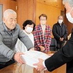 ごみ袋の半額化に賛同する署名を垣内廣明議長（右）に渡す寺田昭一さん＝丹波市氷上町成松