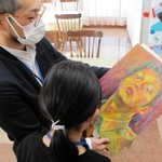 高校生の頃の作品を娘に見せる男性。「うまい。才能あると思う」と言われた＝植野記念美術館