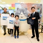 藤田光人・丹波総局長（右）から記念品を受けとった宮崎龍樹さん、颯真君、結衣さん家族＝丹波ゆめタウン