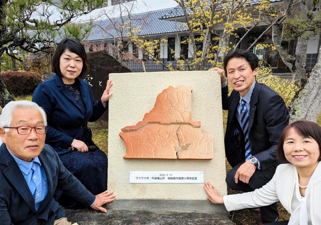 完成した陶製モニュメントと姉妹都市提携委員会のメンバー＝丹波篠山市北新町