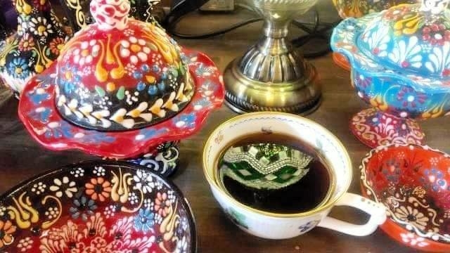 おじま恵さんの作品。ランプが映ったコーヒーカップとカラフルな器たち＝丹波篠山市河原町（提供）