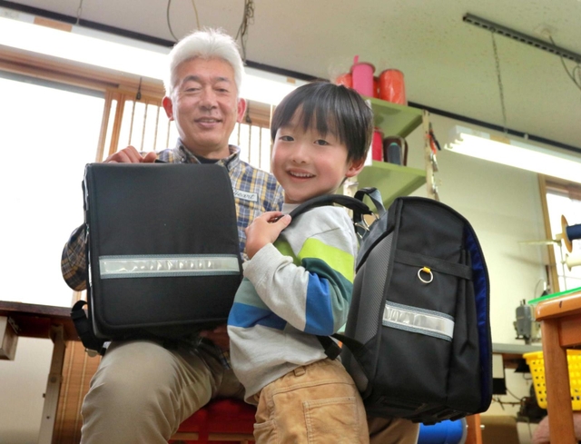 孫の中江咲真君（右）のため片手で開閉しやすいランドセルを作った細川晋さん＝丹波市柏原町柏原、マルスバッグ