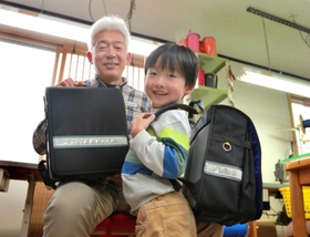 孫の中江咲真君（右）のため片手で開閉しやすいランドセルを作った細川晋さん＝丹波市柏原町柏原、マルスバッグ
