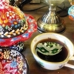 おじま恵さんの作品。ランプが映ったコーヒーカップとカラフルな器たち＝丹波篠山市河原町（提供）