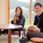 「里山ホテル　かねのね丹波」の部屋で、愛犬を抱く笹西真理さんと哲矢さん＝丹波市柏原町上小倉