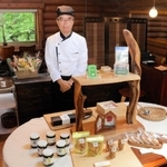 丹波篠山市産の黒豆を使った和スイーツを製造販売する「丹波樂膳」の吉本博次代表。奥が併設のカフェスペースとなっている＝丹波篠山市味間奥