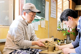 陶勝窯の市野勝磯さん（右）から一対一でサポートを受けながら陶芸体験した＝丹波篠山市今田町上立杭