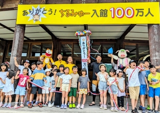 入館者１００万人達成を祝う関係者や地元の児童ら＝丹波篠山市小田中