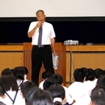 児童を前に講演する長沢宏行さん＝味間小学校体育館