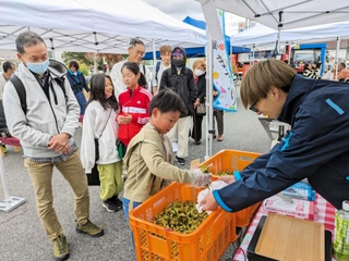 人気を集めた黒枝豆のつかみ取り＝神戸新聞春日専売所