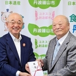 酒井隆明市長（左）に寄付金の目録を手渡す井関道夫さん＝丹波篠山市役所