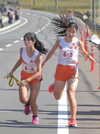 女子・柏原の３区長谷川未優選手（右）からたすきを受け取る４区金子澄音選手＝丹波篠山市内（撮影・風斗雅博）