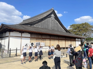 グループに分かれ、篠山城跡の大書院前でクイズを交えたガイドをする篠山小学校の６年生＝２０２３年１０月、丹波篠山市北新町（篠山小提供）