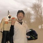 自身が２０１９年に記録した５０ｃｃバイクの最速記録を塗り替えた近兼拓史さん。背景は記録樹立の瞬間の映像＝ヱビスシネマ。