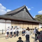 グループに分かれ、篠山城跡の大書院前でクイズを交えたガイドをする篠山小学校の６年生＝２０２３年１０月、丹波篠山市北新町（篠山小提供）
