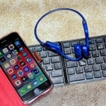 酒井さん愛用のスマートフォンと入力用キーボードと骨伝導イヤホン
