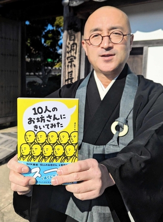 自らも登場する書籍「１０人のお坊さんにきいてみた」を手にする安達瑞樹・長楽寺住職＝丹波篠山市郡家