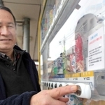 児童が作った景品を販売する自販機と余田康夫さん＝余田商店