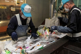 プラスチックを分別する丹波市クリーンセンターの職員＝丹波市春日町野上野