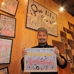 顔をテーマにしたイラストを描く足立遥紀さんと作品＝マミムメモ・ブックブック