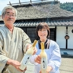 農家民宿「森の風土」の前で、どぶろく「森のふど子」を手にする唐渡たかねさん（右）と民宿オーナー森田忠さん＝丹波篠山市川原