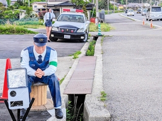 国道１７６号の道路脇に設置されたリアルな警官人形とパトカー風の車両＝丹波篠山市南矢代