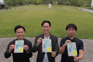 チラシを手にする実行委員会のメンバーたち。後方の芝生広場がフェス会場になる＝丹波の森公苑