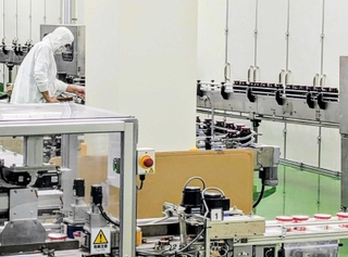 ジャム工場のラインを流れるジャムのびんやカップ＝丹波篠山市北