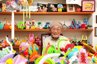 ８０歳を過ぎてから始めた折り紙の作品に囲まれる足立修三さん＝丹波市青垣町山垣