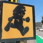走行中の車に飛び出しへの注意を促す道路横の表示。ゲームで有名な配管工の「彼」に似たシルエットが目を引く＝丹波篠山市宮田