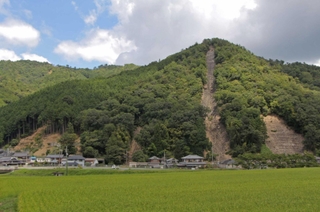 丹波豪雨で崩れ、現在はコンクリートで補強されている山の斜面。自然の猛威の記憶を今に伝える＝丹波市市島町徳尾