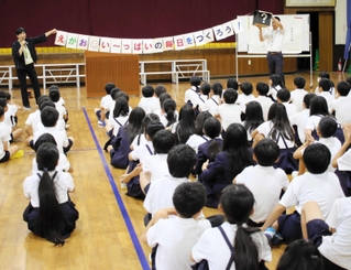 児童を前に、２学期のスローガンを掲げる押部匡子校長（左奥）＝篠山小学校