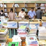 古い本を書架から抜いて整理するボランティアら＝北小学校