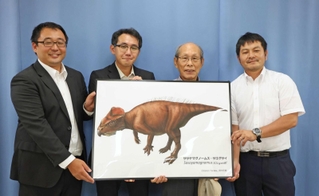 新属新種の角竜「ササヤマグノームス」のイメージ図を手に笑顔を見せる足立洌さん（右から２人目）ら＝３日午後、兵庫県庁
