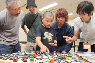 ミニカーのコレクションを前に、大人たちとイベントについて考える小沢奏太さん（中央）＝丹波市市民プラザ