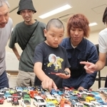 ミニカーのコレクションを前に、大人たちとイベントについて考える小沢奏太さん（中央）＝丹波市市民プラザ