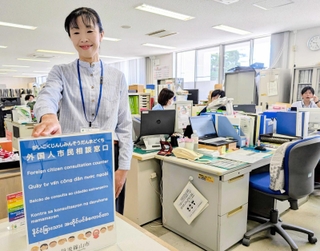 新設された「外国人市民相談窓口」と相談員の崎田薫さん。ボードはベトナム語、ミャンマー語など６言語で表記されている＝丹波篠山市役所