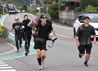 約１５キロの丸太を担ぎ懸命に走る参加者＝丹波篠山市垣屋