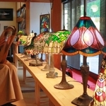 色とりどりのステンドグラスのランプが並ぶ展示会場。たて琴「ライアー」の演奏会も開かれる＝丹波篠山市今田町木津