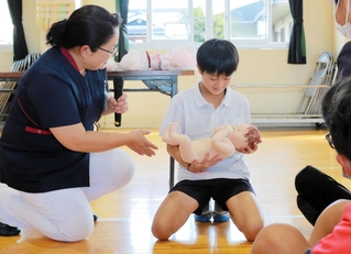 命の授業で赤ちゃん人形を抱く児童＝丹波篠山市糯ケ坪