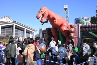 空気でふくらませた恐竜の遊具。子どもらに大人気で列ができる＝丹波市山南町谷川
