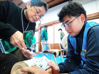 西脇北高校の生徒（右）に教わりながら竹灯籠を作る参加者＝丹波篠山市立町