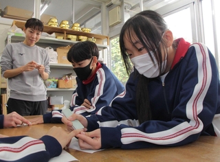 クラスメートの爪を磨く生徒たち＝氷上特別支援学校