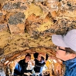 「最古の登窯」の内側の壁に、粘土をぶつけて貼りつかせ、補修する窯元の関係者たち＝丹波篠山市今田町上立杭