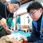 西脇北高校の生徒（右）に教わりながら竹灯籠を作る参加者＝丹波篠山市立町