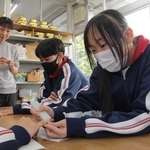 クラスメートの爪を磨く生徒たち＝氷上特別支援学校