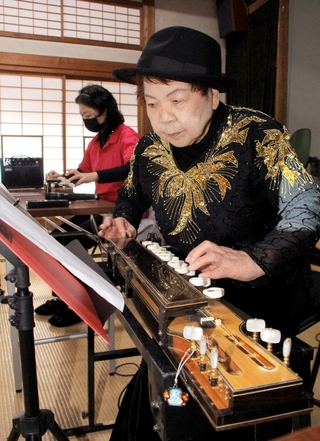 大正琴の演奏で感謝の気持ちを表す善本凉子さん＝新郷公民館