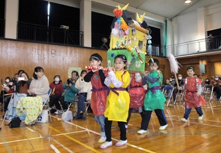 手作りしたみこしを担いで創立１５０年を祝う１年生たち＝船城小学校